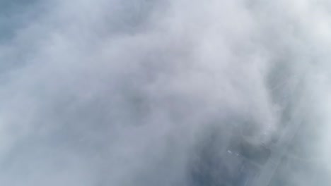 Flight-over-misty-clouds-in-morning-sunlight-with-little-glory-and-city-scape-under-clouds