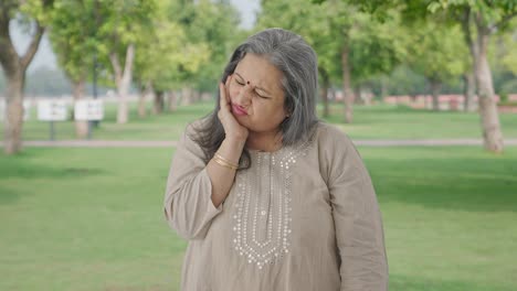 Sick-Indian-old-woman-suffering-from-tooth-pain-in-park