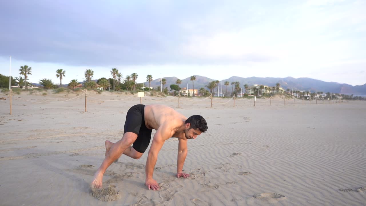 shirtless muscular man doing metabolic training with floor exercise on the beach