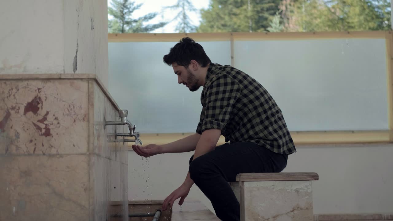 joven musulmán tomando abluciones para rezar en la mezquita 1