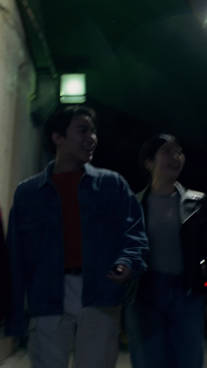 Friends Walking at Night in a City Tunnel