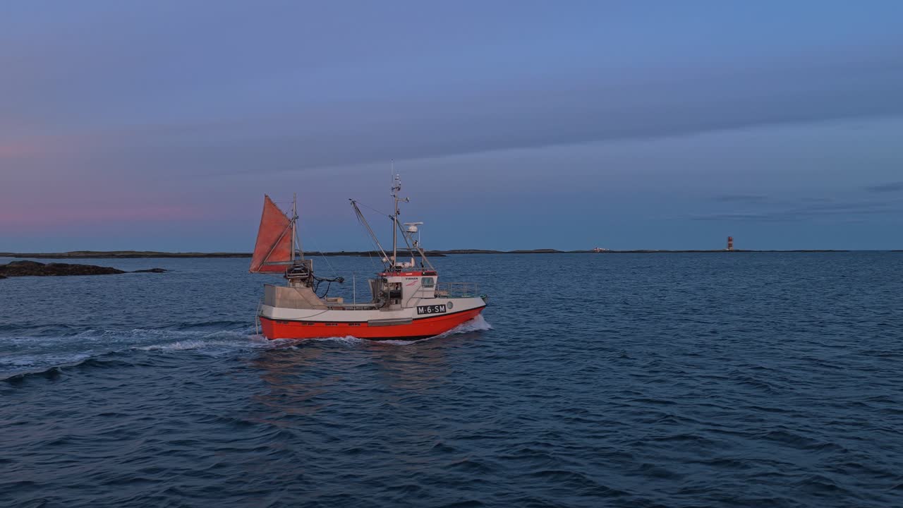 Barca da pesca in legno naviga su mare tranquillo all'alba, Norvegia.