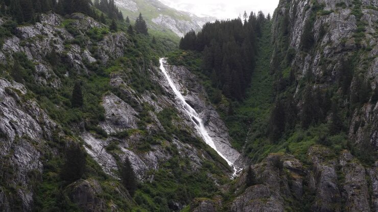 Cascata su una ripida scogliera granitica delle montagne, fiordo di Endicott Arm, Alaska.