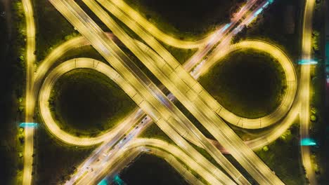 Time-lapse or Hyper-lapse Aerial view highway road roundabout circle or intersection traffic at night for transportation concept.