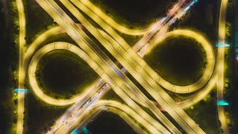 time-lapse or hyper-lapse aerial view highway road roundabout circle or intersection traffic at night for transportation concept.