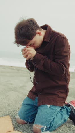 faithful man praying with passion with the bible book on the beach