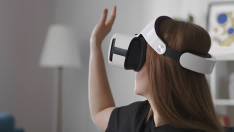 woman is using head-mounted display touching virtual screen by hand swiping and tapping portrait of female user with device on head modern technology of vr