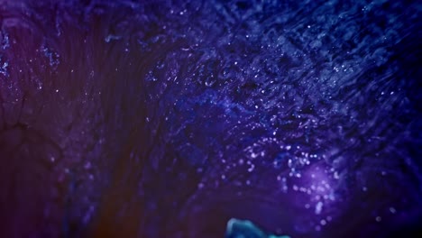 vibrant blue and purple ink swirling in water, abstract background