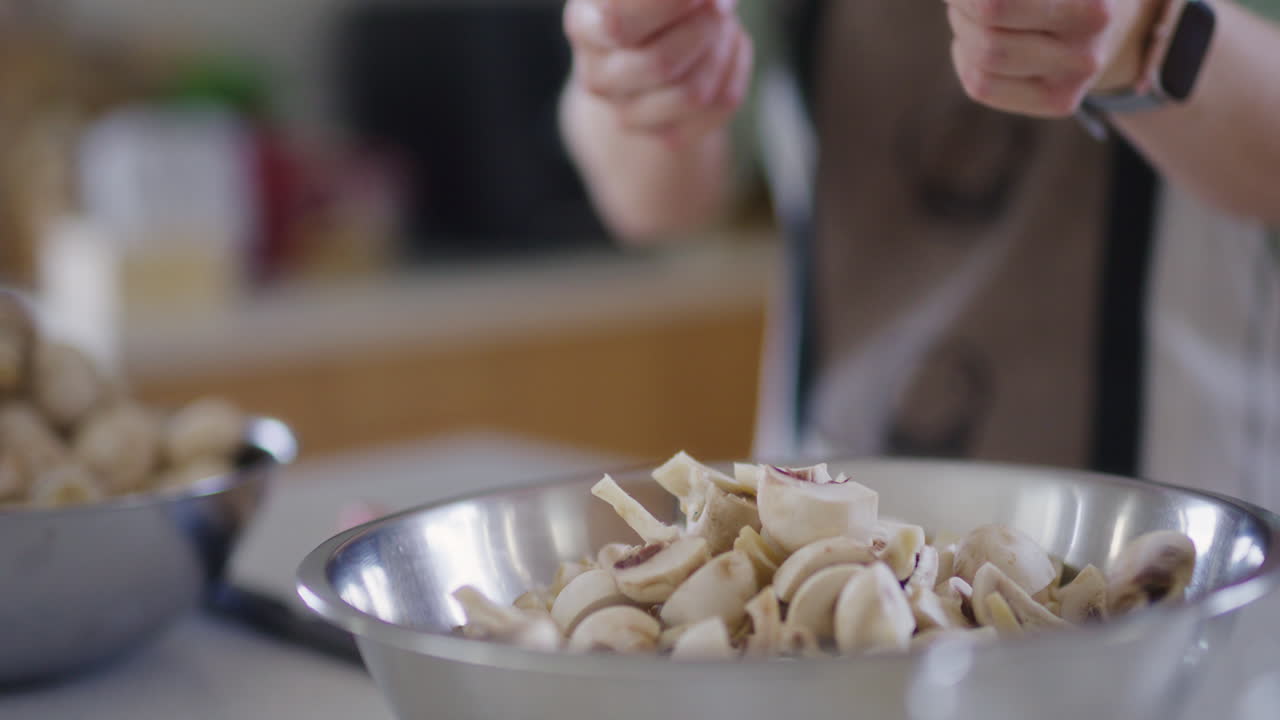 여자 가 조각 된 버섯 을 그 에 부어 넣고 있다