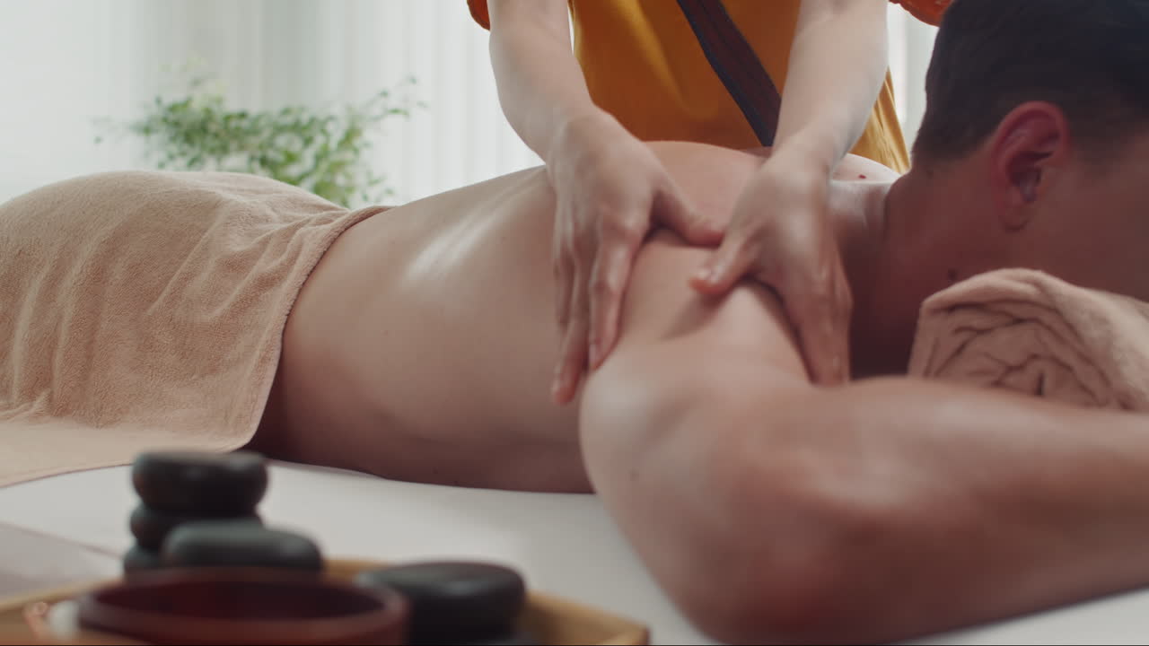 Masseuse Doing Back Massage to Man