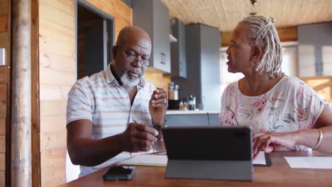 senior african american couple doing paperwork using tablet at home, slow motion