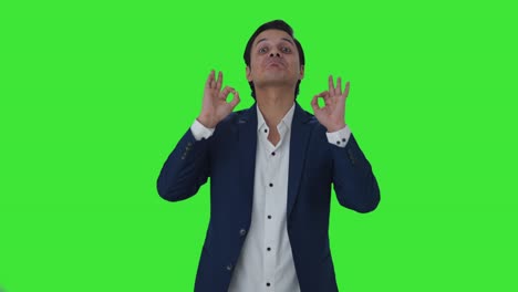 Happy-Indian-journalist-showing-okay-sign-Green-screen