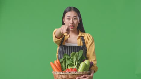 woman pointing at vegetables in a basket