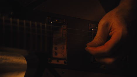 primer plano de los dedos tocando la guitarra eléctrica