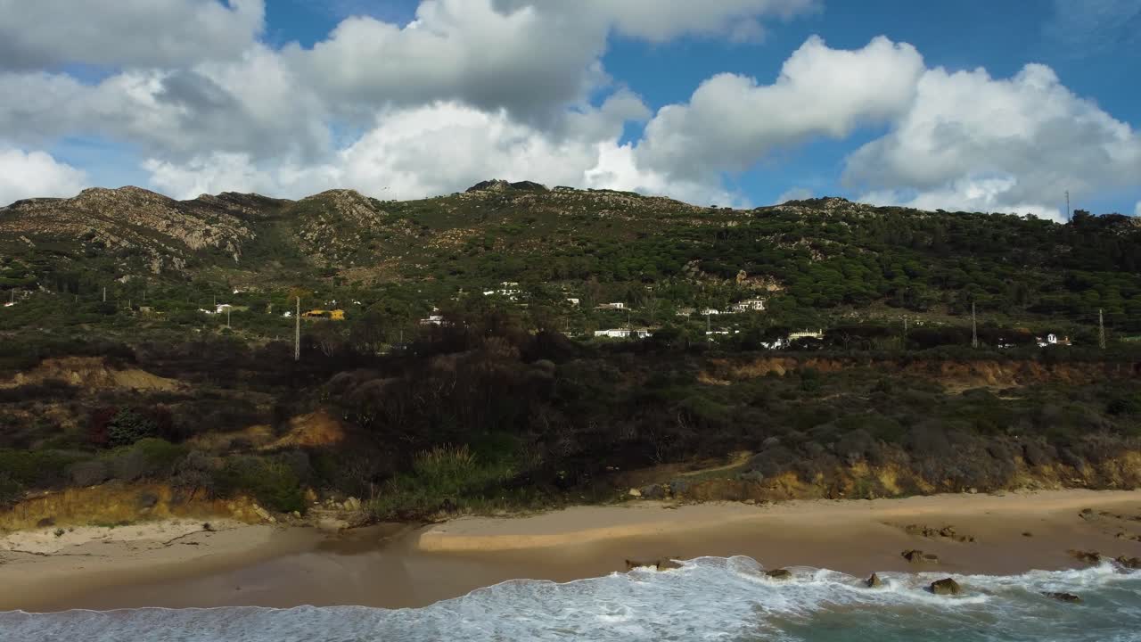 playa de arena y casas privadas en la ladera en españa, vista aérea ascendente
