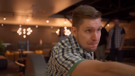 Multi-ethnic-Group-of-friends-in-a-bowling-club-Portrait-of-a-Caucasian-man-throws-a-ball-and-knocks-out-a-strike