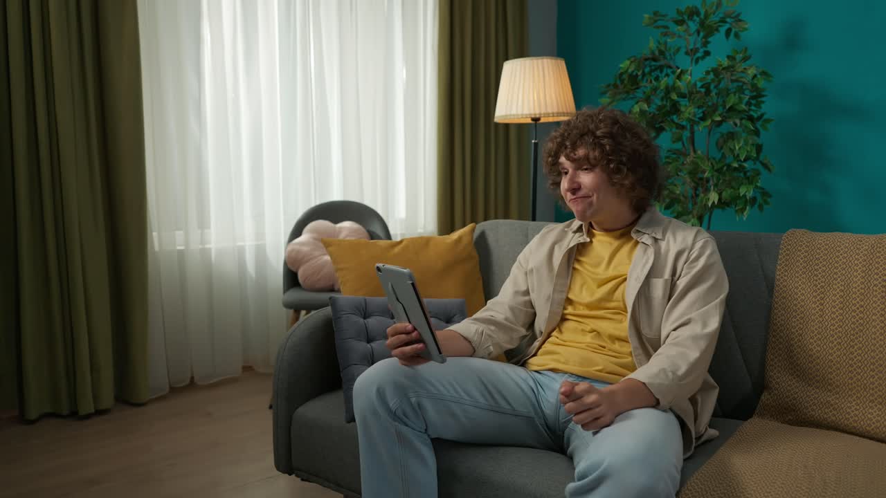 Young Man Video Chatting on a Tablet