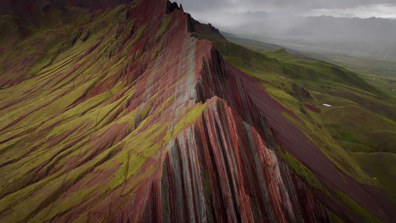 Montagna Arcobaleno Pallay Punchu vicino a Cusco, Perù, che rivela drammatiche creste striate e strati geologici colorati su terreno montuoso, vista aerea