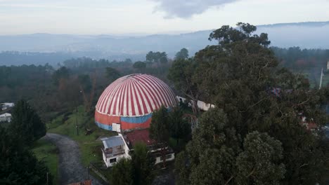 Benposta-circus-tent-reveals-as-drone-rises-above-treeline-canopy