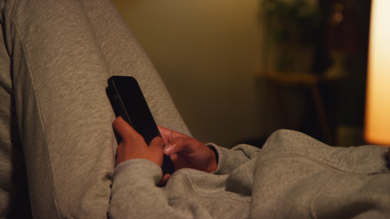 Person using a phone at home in the evening