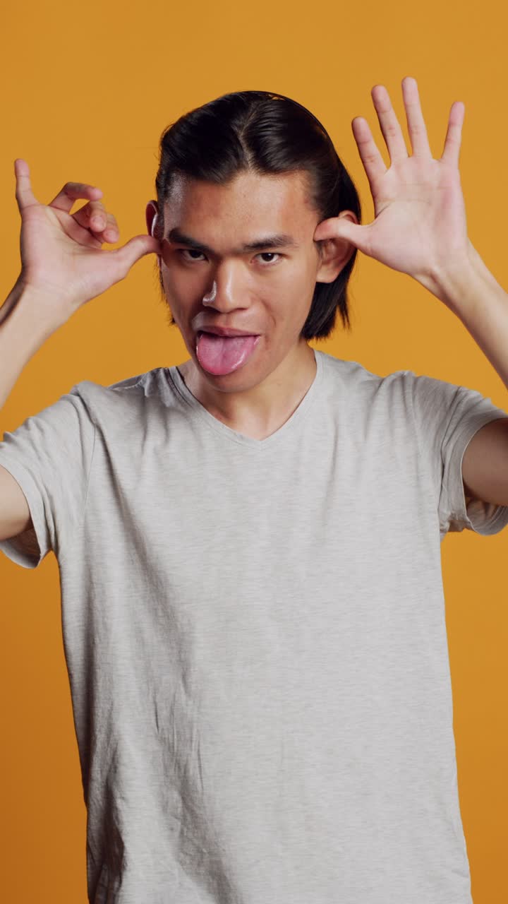 Vertical video: Amusing guy sticking tongue out and acting funny