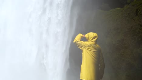 Mujer-Con-Chaqueta-Amarilla-Skógafoss-En-Islandia,-4k