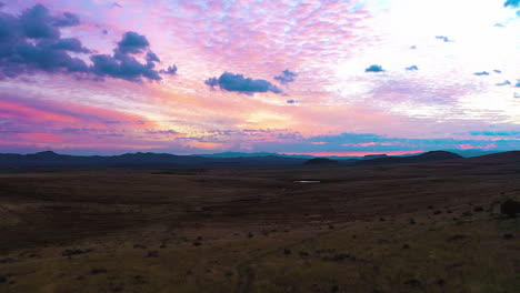 Drone-shot-of-a-calming-sunrise-with-pastel-colored-skies-in-a-secluded-valley