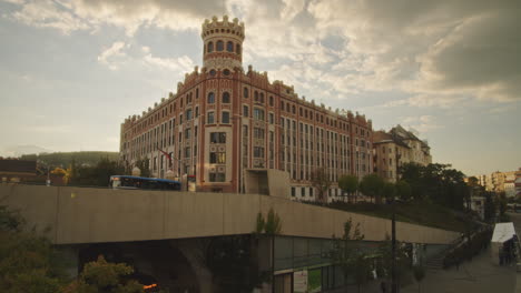 iconic building on the corner of szell kalman square the public transport bus is waiting at the end station