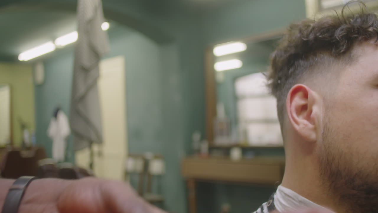 Barber Shaving Beard Neckline of Client with Electric Razor