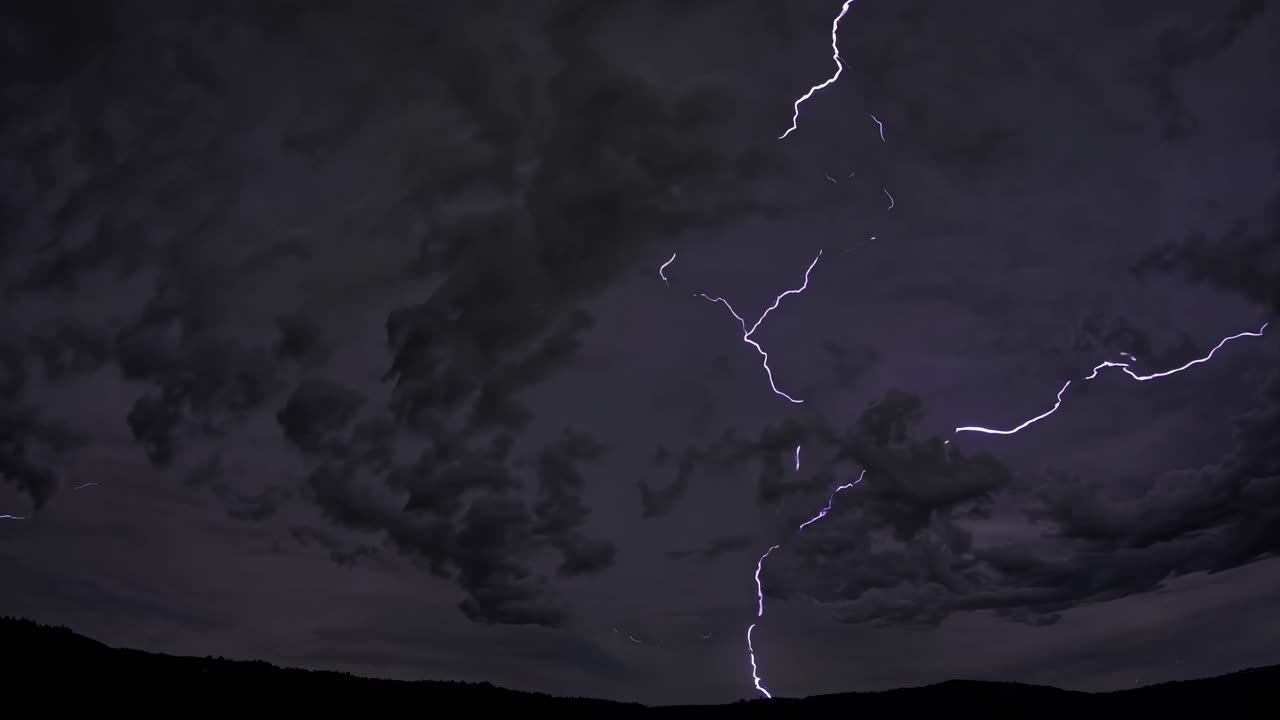 Dramatic wide-angle shot of a stormy sky with vivid purple lightning