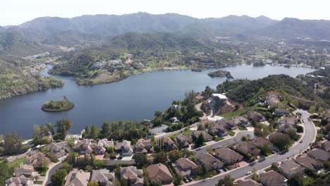 Wide descending aerial shot of lakefront luxury homes in Lake Sherwood, California. 4K at 30 FPS