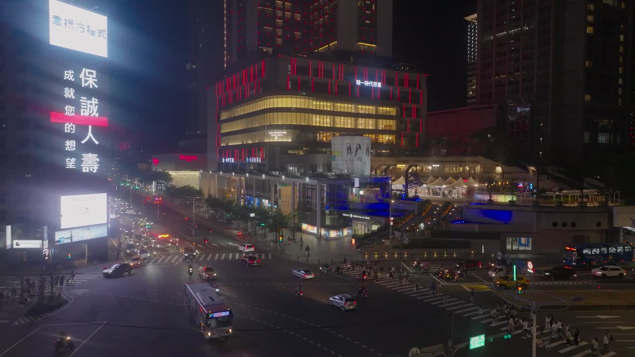 High humidity in downtown of asian metropolis at night. Lighting downtown of Taipei with traffic on street. Shopping mall in background. Aerial approaching shot. Fogged lens of camera.