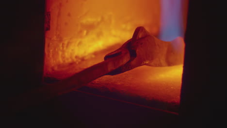 a blade being held in a forge with a pair of tongs