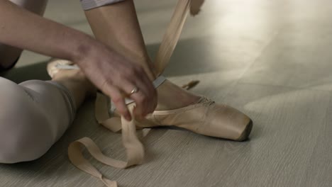 ballet dancer tying pointe shoes