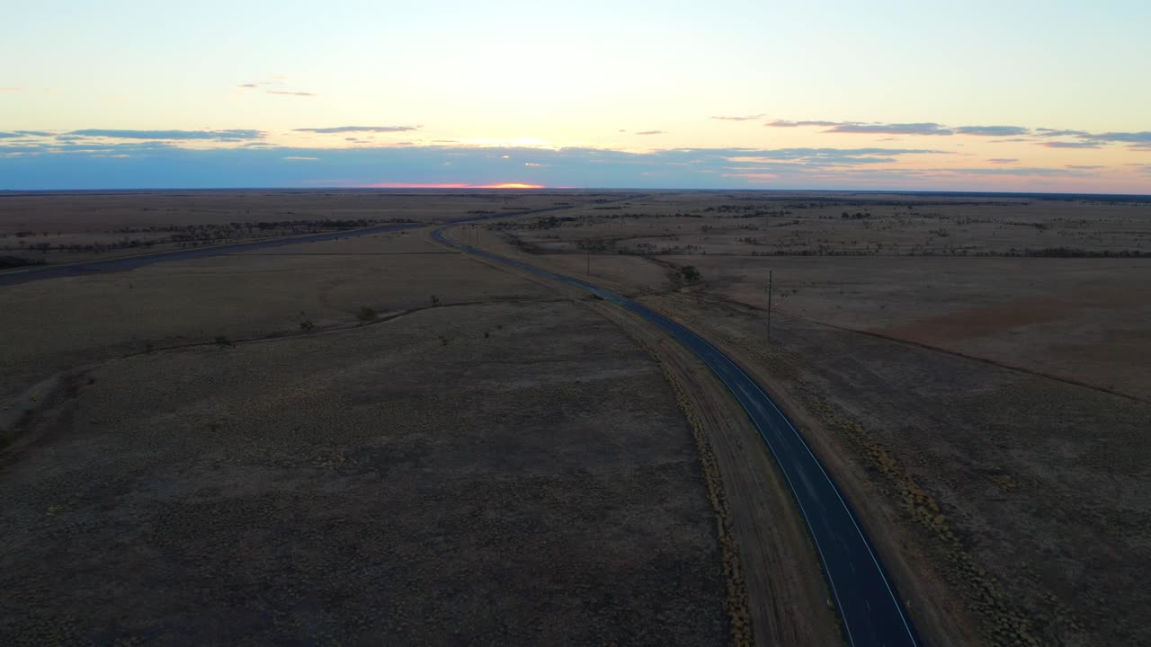 узкая асфальтированная дорога в пустыне во время заката в австралийском штате квинсленд