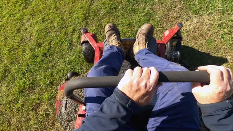 a groundsman starts a ride-on lawn mower and begins cutting grass on an oval