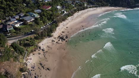 Olas-Del-Océano-Salpicando-La-Costa-Arenosa-En-La-Pequeña-Playa-De-Wategos-En-Nsw,-Australia---Disparo-Aéreo-De-Drones