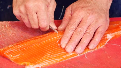 close-up of a chef filleting fresh salmon