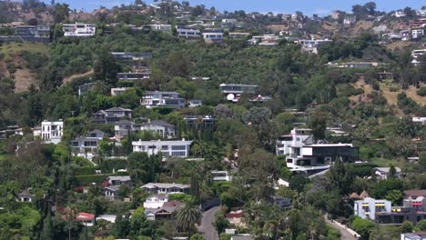 fly from behind a skyscraper to reveal the famous bird streets mansions in hollywood hills, california