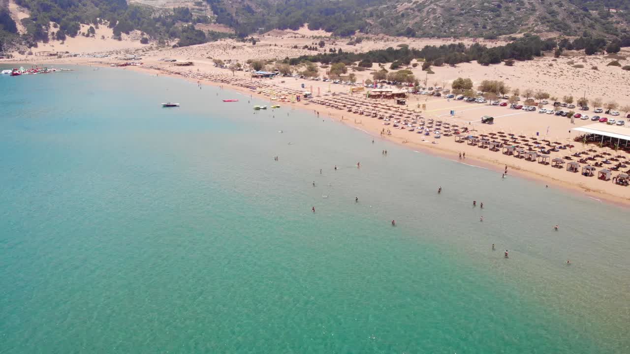 Tourists Enjoying Summer At The Pristine Beach Of Tsambika On Rhodes Island In Greece