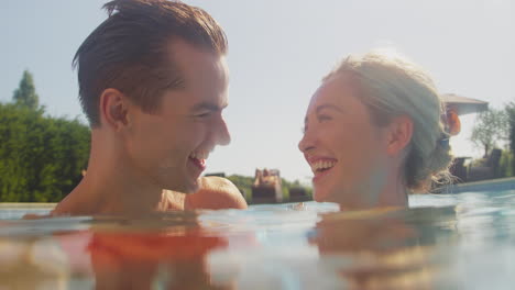 portrait of loving couple on summer holiday relaxing in swimming pool