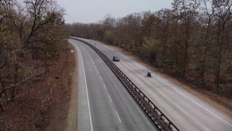 aerial drone shot of the iconic nh44 srinagar to kanyakumari 6 lane highway that cuts through the pench national park with underpass for wild animals to cross, india