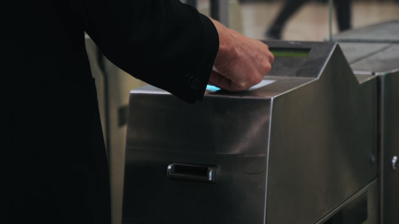 Man with contactless card in metro in Barcelona, hand ticking transport ticket in the machine mobile phone on train station. NFC and contactless technology concept