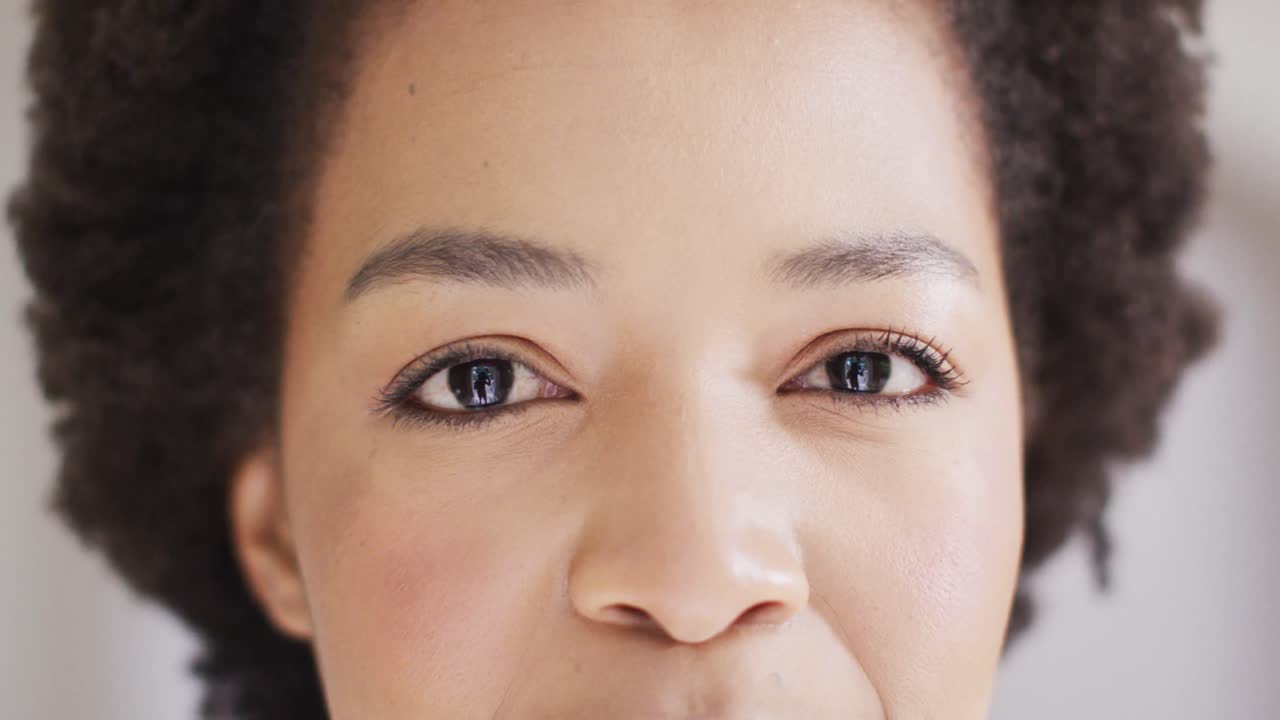 retrato de cerca de los ojos de una feliz mujer afroamericana sonriendo, en cámara lenta