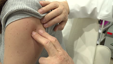 doctor examining patient's vaccination injection site