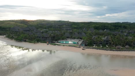 Bright-first-light-shining-over-mountain-behind-famous-Intercontinental-resort-at-Natadola-Bay-in-Fiji,-aerial