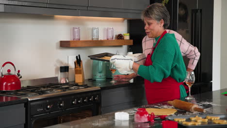 senior women baking christmas cookies together, enjoying festive holiday spirit