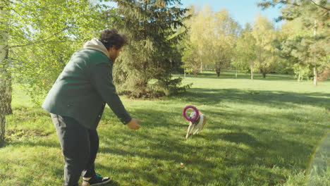man playing fetch with dog in park