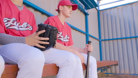 young baseball players eagerly awaiting their chance to play in the dugout during games