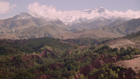 Establishing-shot,-lush-valleys-in-front-of-the-towering-mountains-of-the-High-Atlas-range-in-Morocco